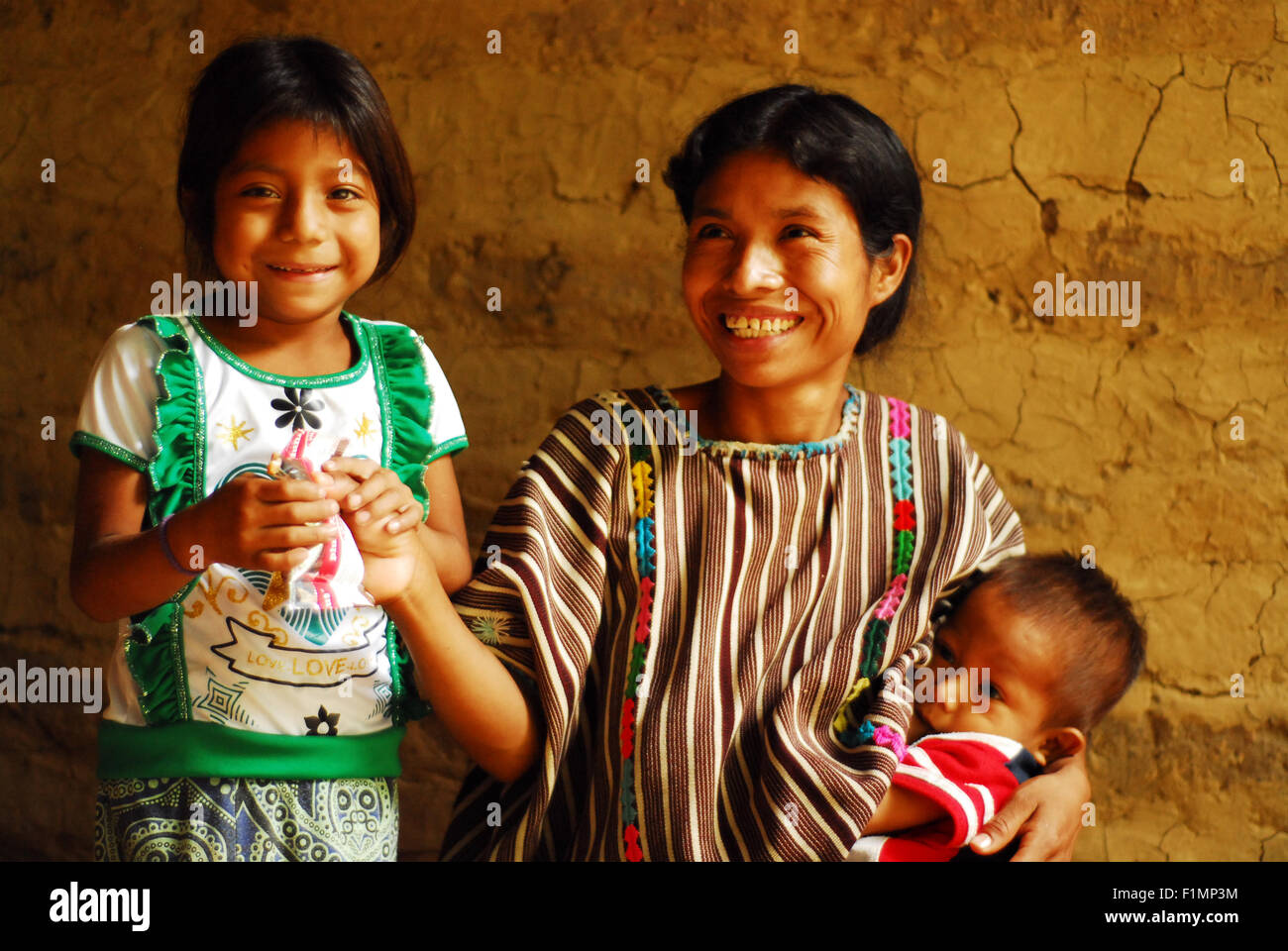 Guatemala, la Democratia, mother (Andrea Mendez Hernandez 33) breastfeeding baby (Horacio Lopez Mendez 1 year) and giving Plumpy nut pack to daughter (Lorena Lopez Mendez 4 years), (MR) Stock Photo