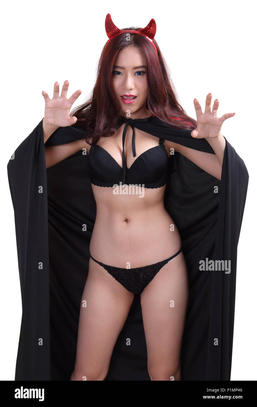 portrait young woman witch in black bikini and devil horns on white  background Stock Photo - Alamy