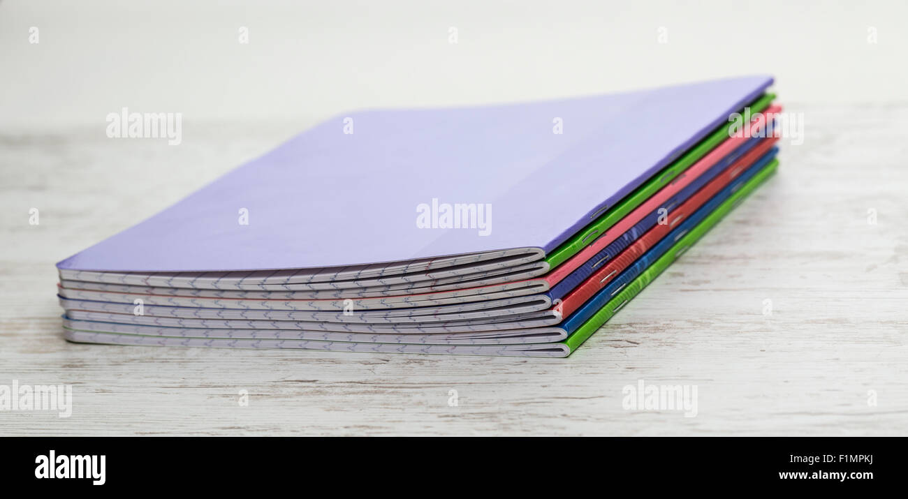 Image of a stack of colorful notebooks on a white wooden table Stock ...