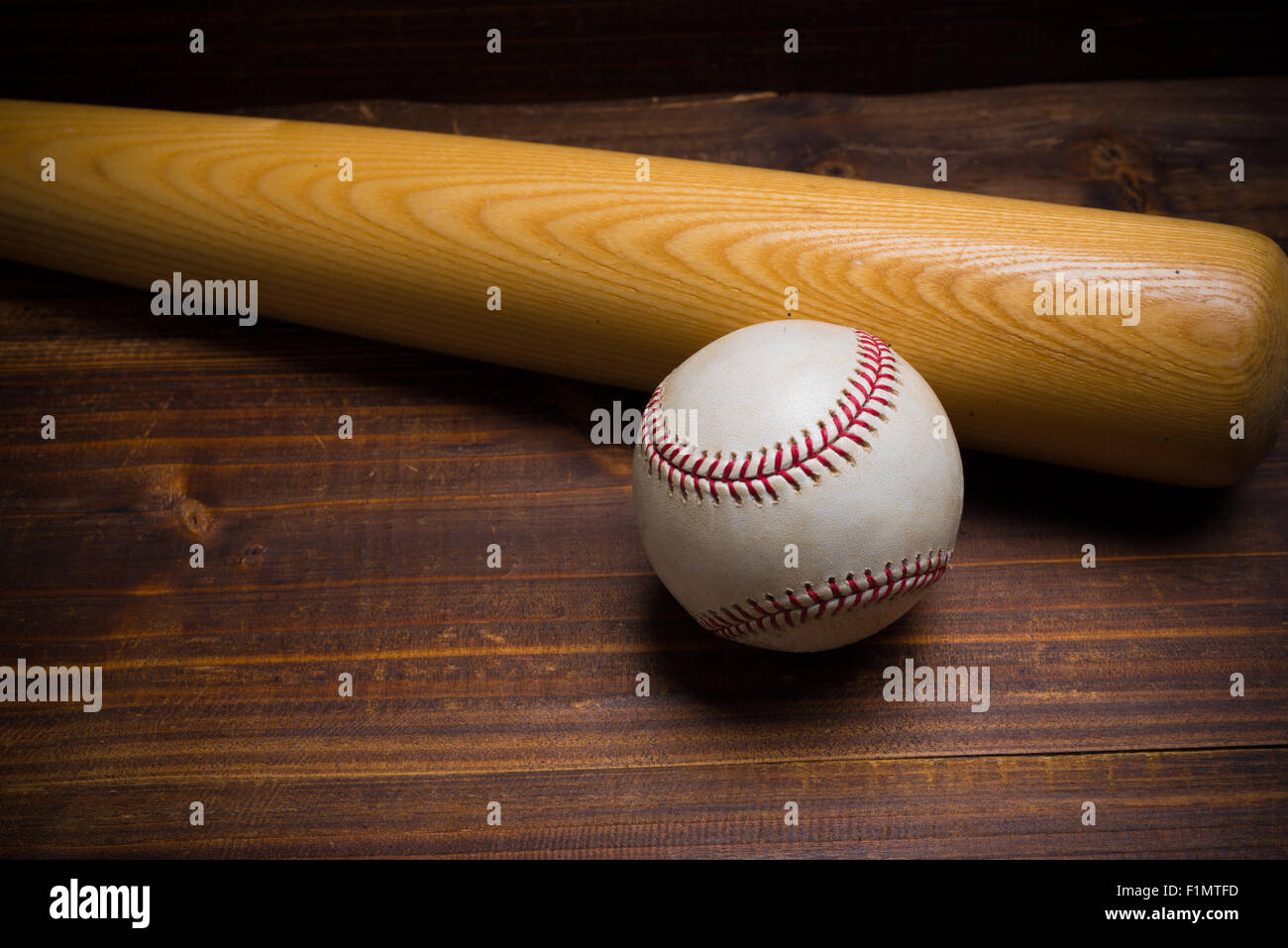 Baseball equipment: wooden bat and ball on a wood plank or bench background Stock Photo