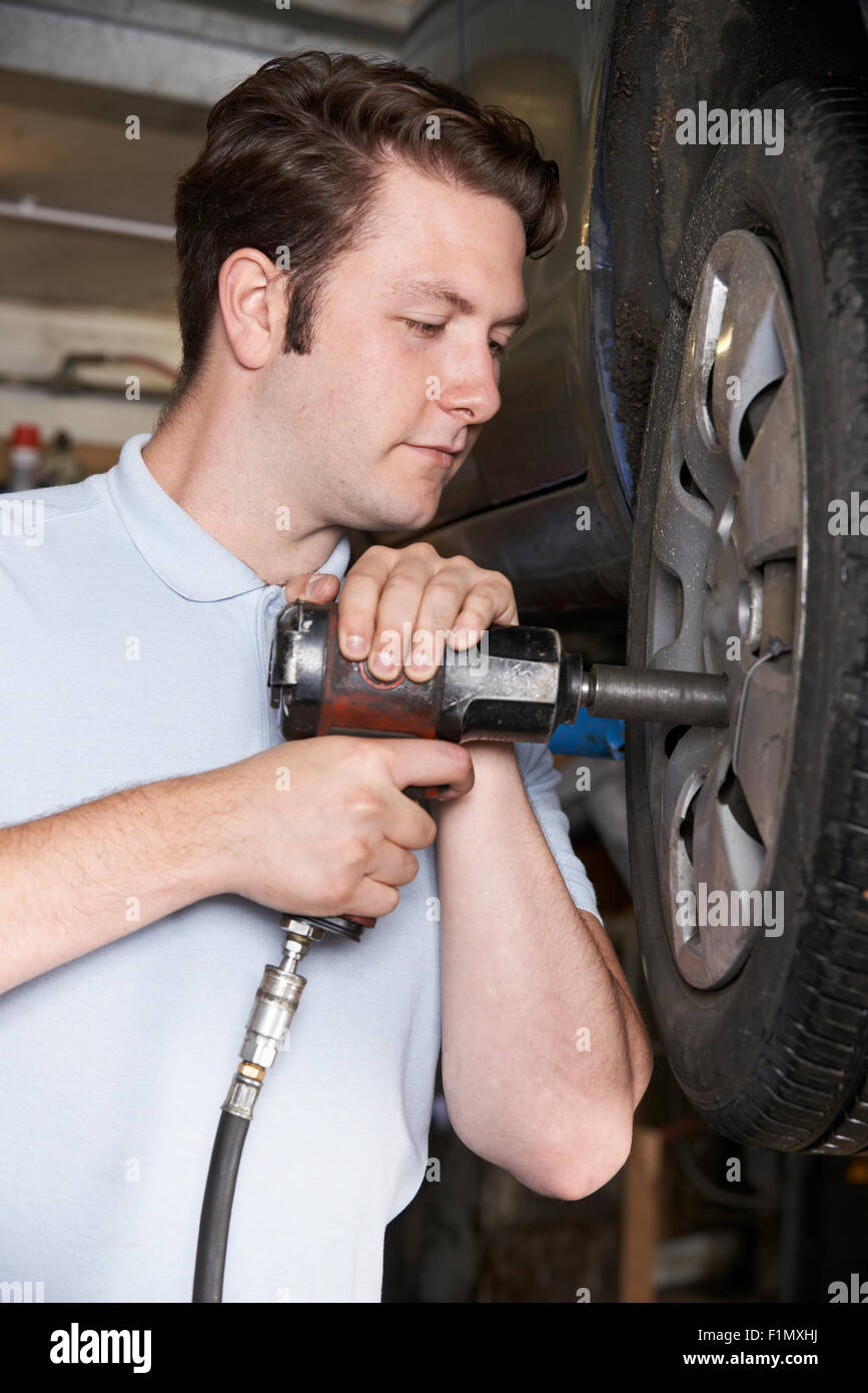 Mechanic In Garage Using Air Hammer On Car Wheel Stock Photo Alamy