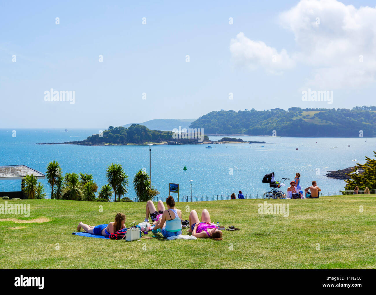 People sunbathing on the Hoe with Drake Island in the distance, Plymouth, Devon, England, UK Stock Photo