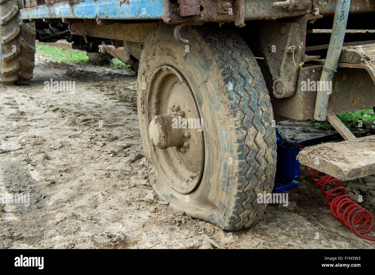 Flat tyre on a farm trailer. Stock Photo
