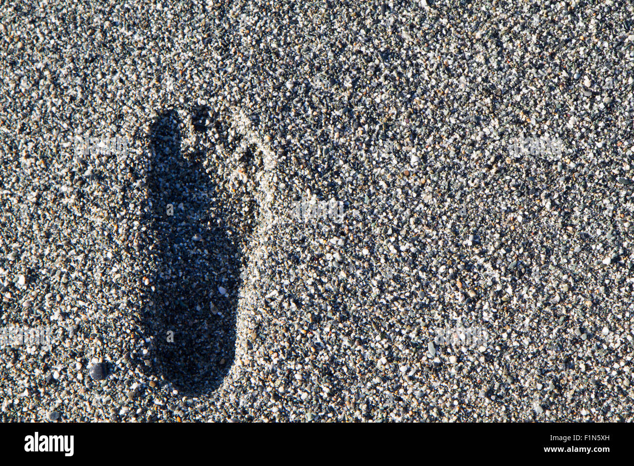 backgroun footprints on the beach of gray stones Stock Photo
