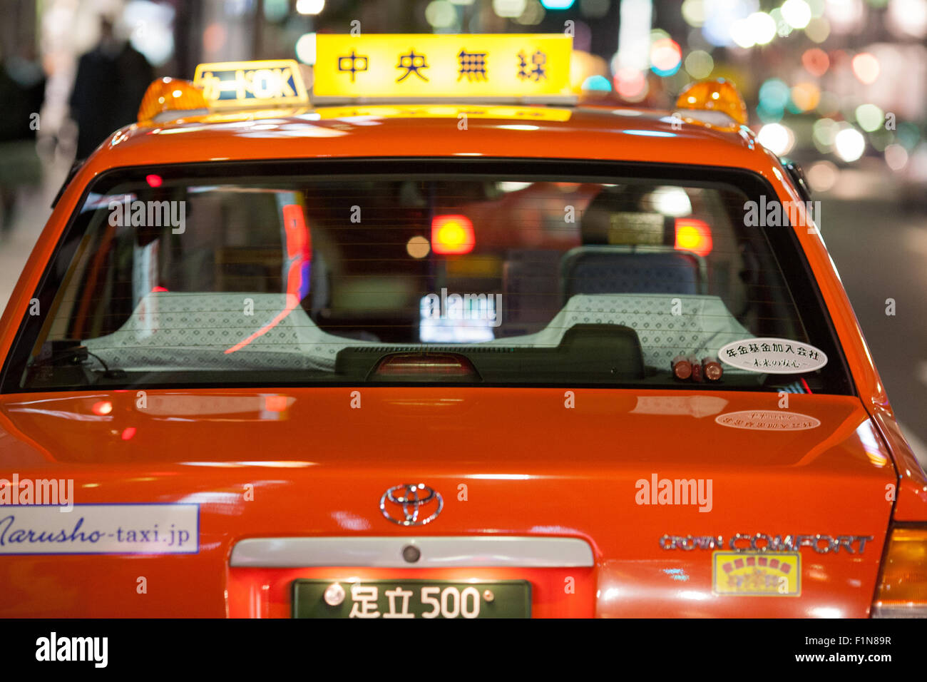 Japanese orange taxi cab from behind with bokeh background lights Stock Photo