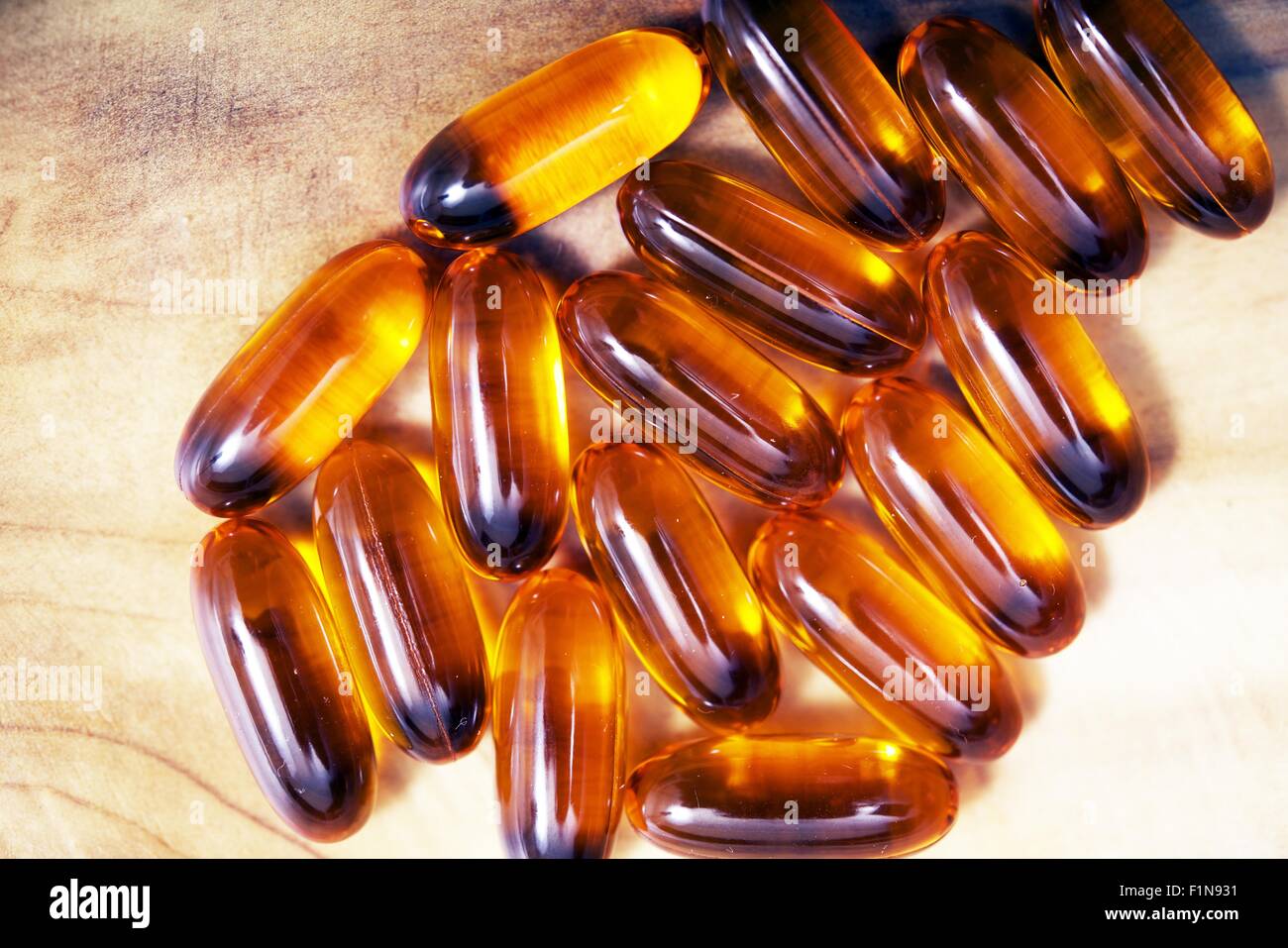 Fish Oil Capsules on Wooden Table Closeup. Stock Photo