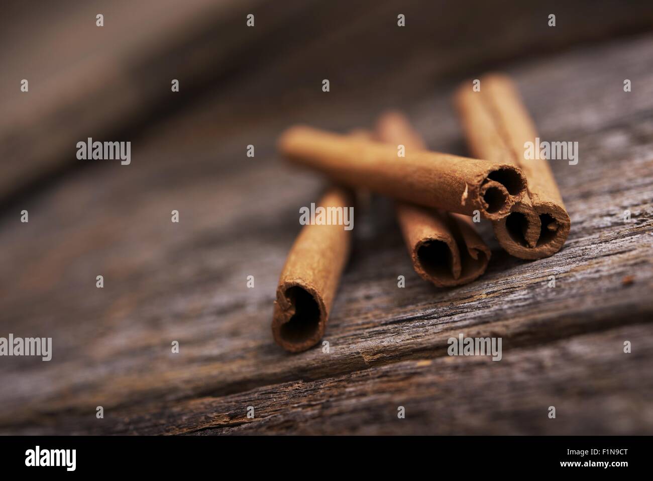 Raw Organic Cinnamon Sticks on Aged Wood Table. Stock Photo