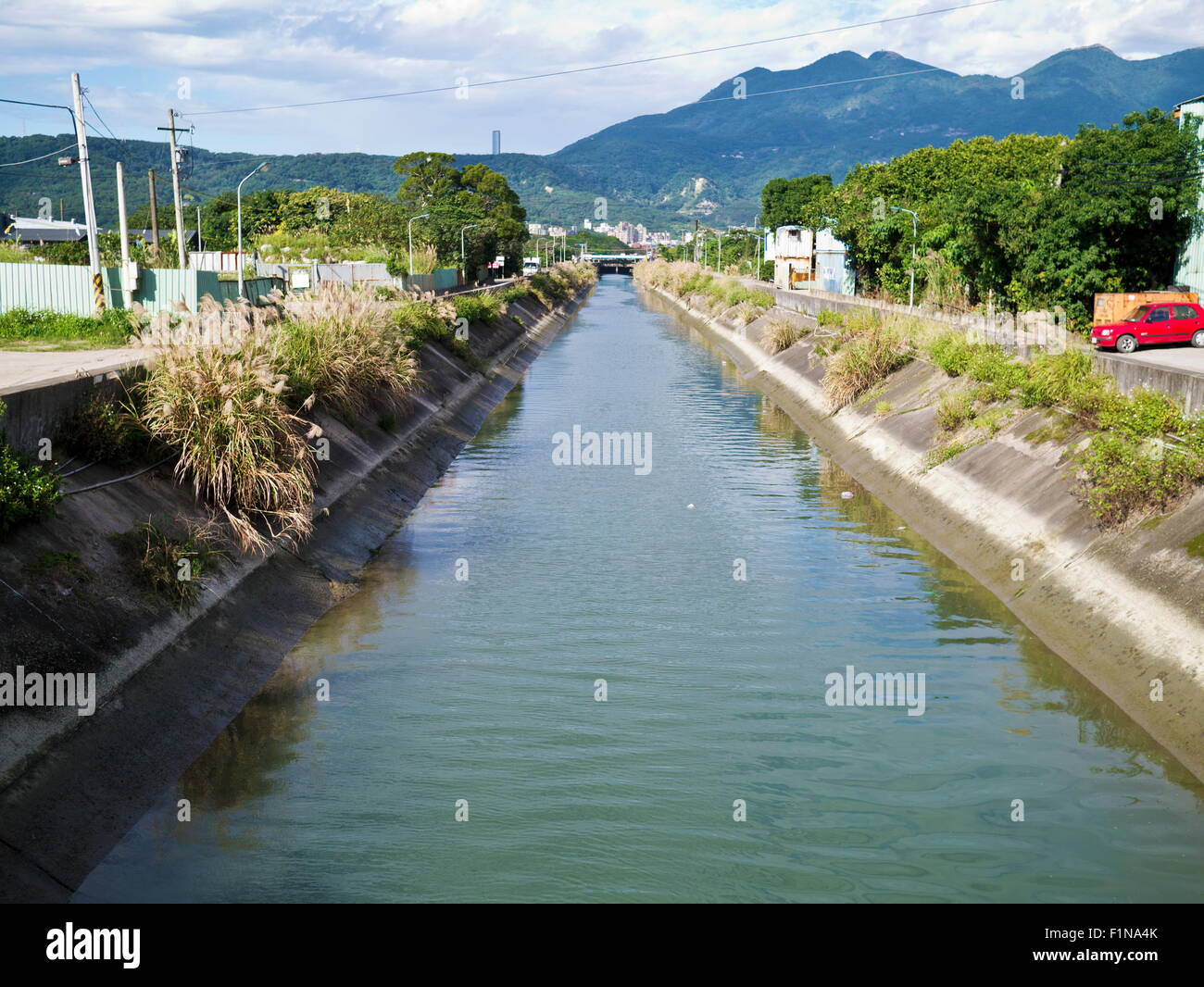 Irrigation canal through city under sunshine Stock Photo