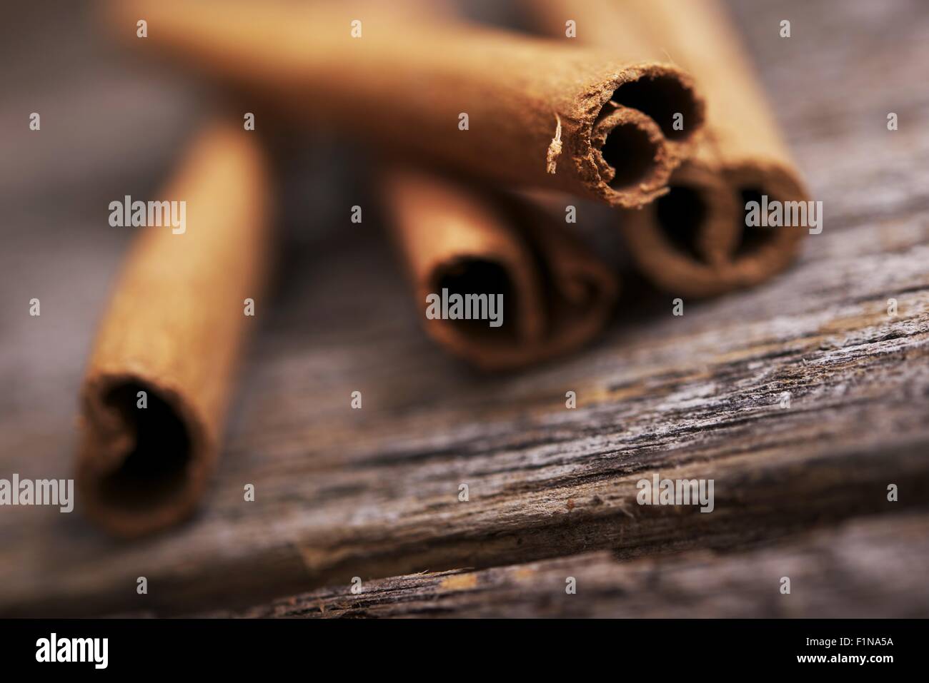 Fresh Aromatic Raw Cinnamon Sticks on Aged Wood. Stock Photo