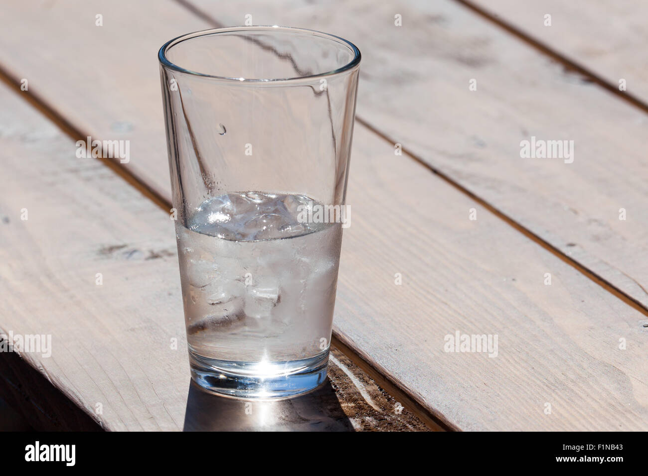 Ice water in a clear glass can either be seen as half full or as half empty Stock Photo Alamy
