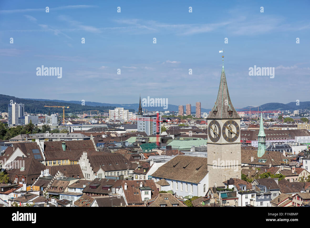 Zurich cityscape - view from the tower of the Grossmunster cathedral with the St. Peter Church in the foreground. Stock Photo