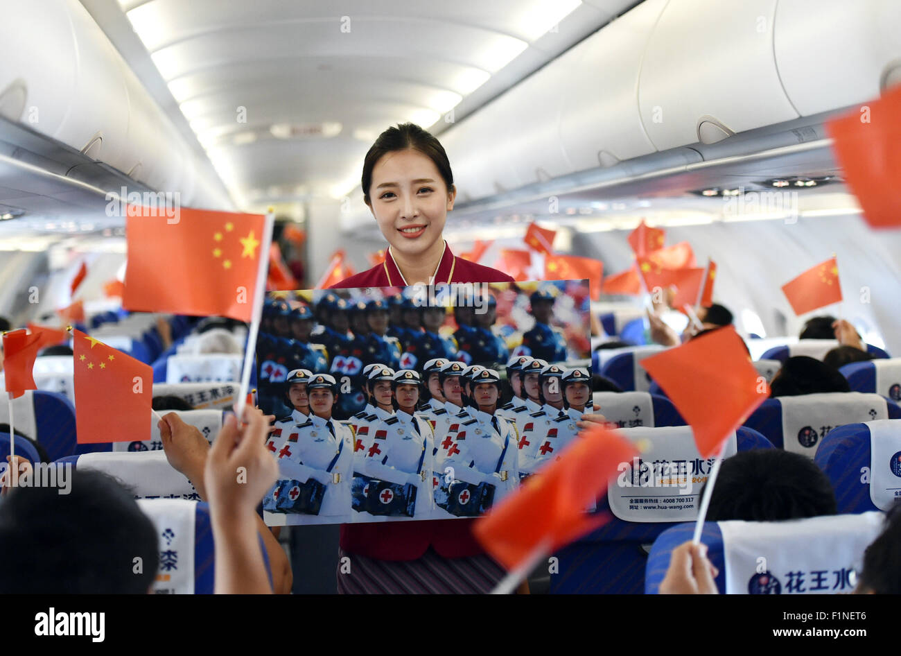 (150905) -- BEIJING, Sept. 5, 2015 (Xinhua) -- A flight attendant shows photos of Beijing V-day parade on flight CZ6366 from Beijing, capital of China, to Haikou, capital of south China's Hainan Province, Sept. 5, 2015. China Southern Airlines started an event called 'In Commemoration of Beijing V-day parade' on a Beijing-Haikou flight Saturday, showing the parade photos for passengers. China on Thursday held commemoration activities, including a grand military parade, to mark the 70th anniversary of the victory of the Chinese People's War of Resistance against Japanese Aggression and the Wor Stock Photo