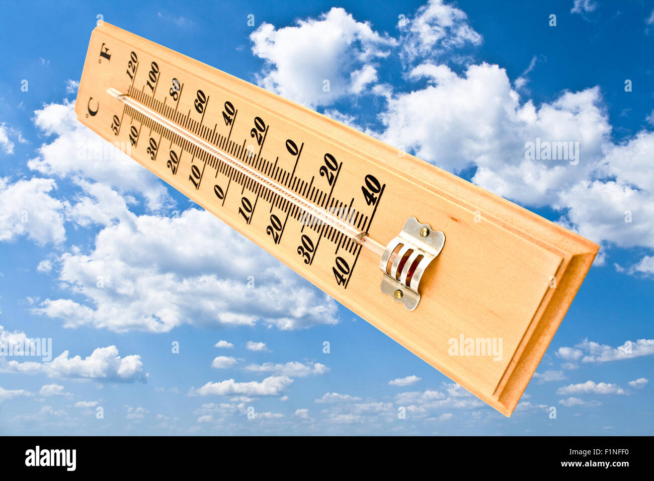 Wooden celsius fahrenheit thermometer over blue sky Stock Photo