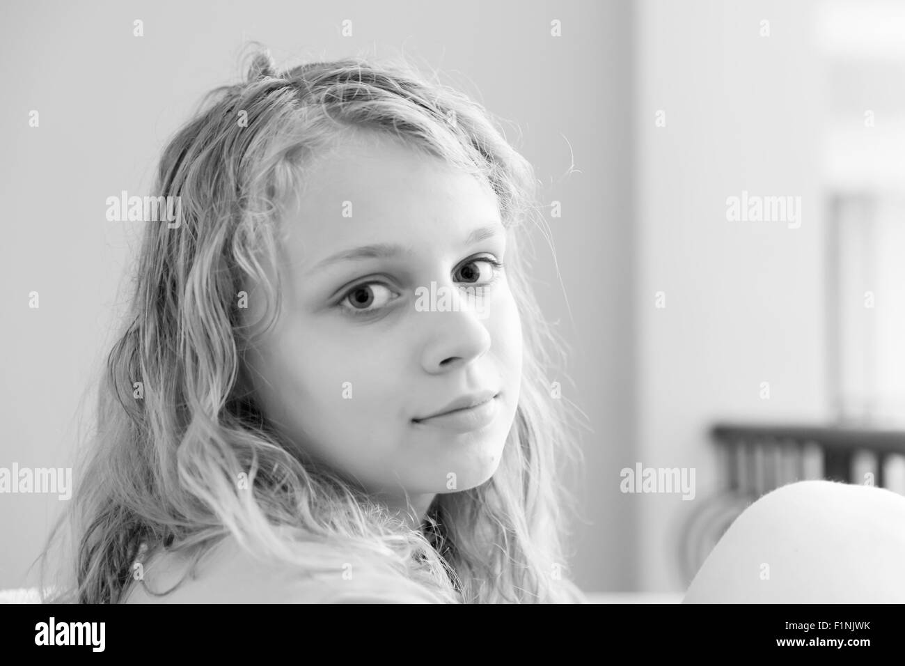 Blond teenage girl closeup monochrome indoor portrait with natural light Stock Photo
