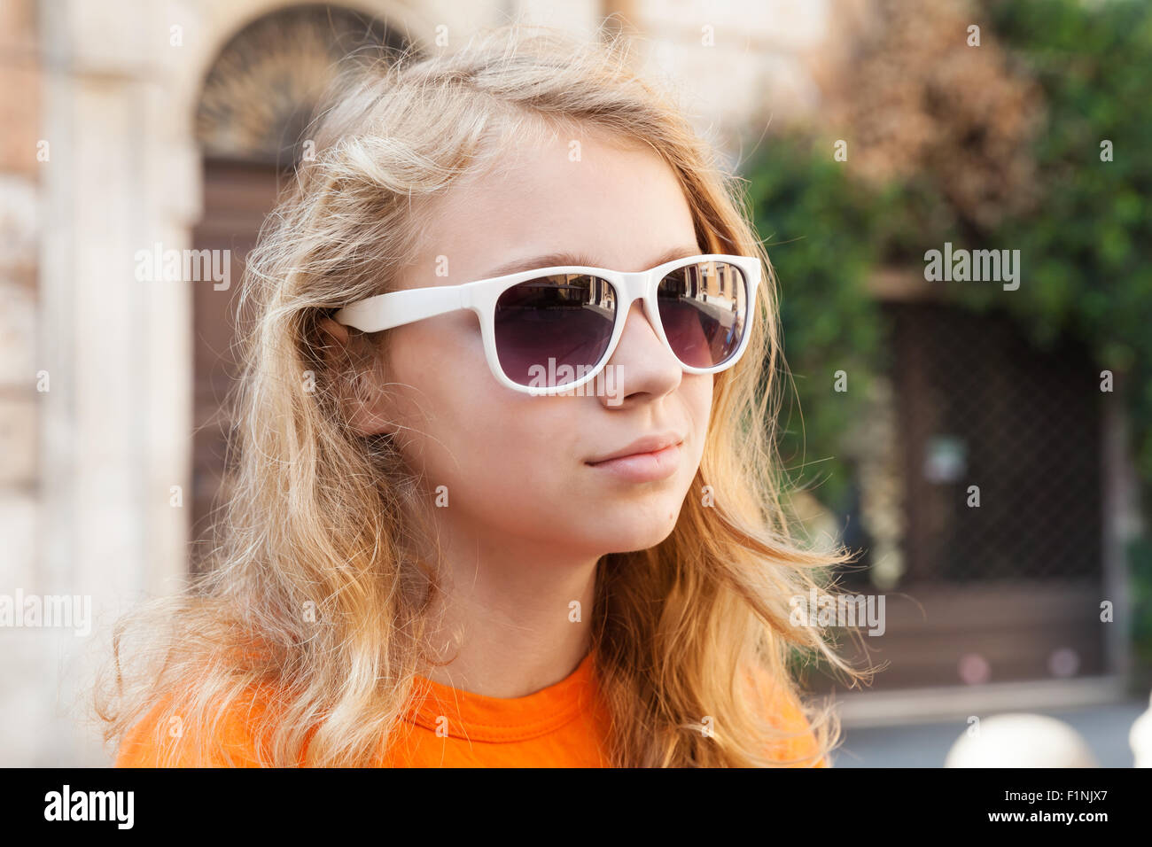 Blond teenage girl in sunglasses, urban summer outdoor closeup portrait Stock Photo