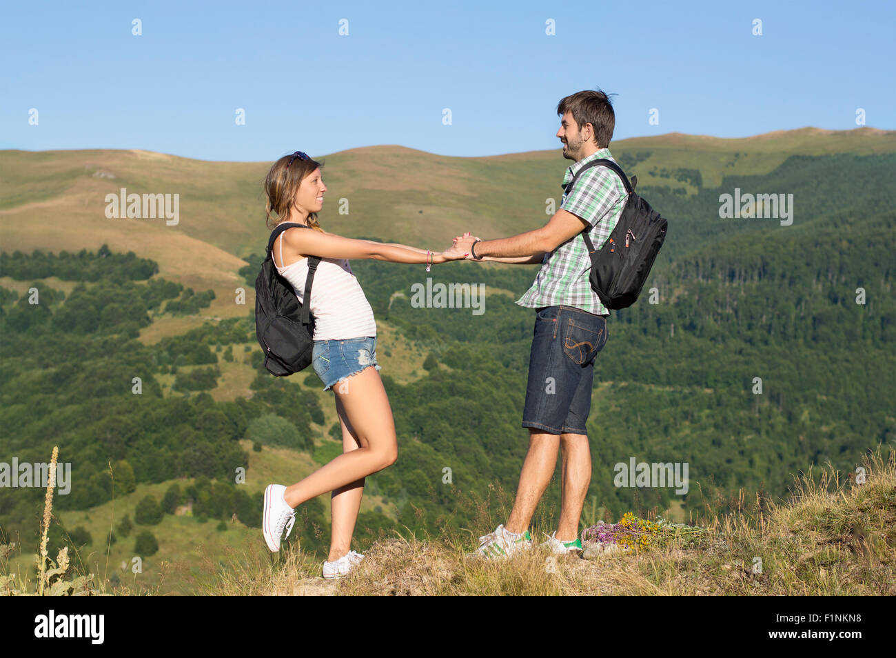 Happy hikers couple in love holding hands in the mountains Stock Photo