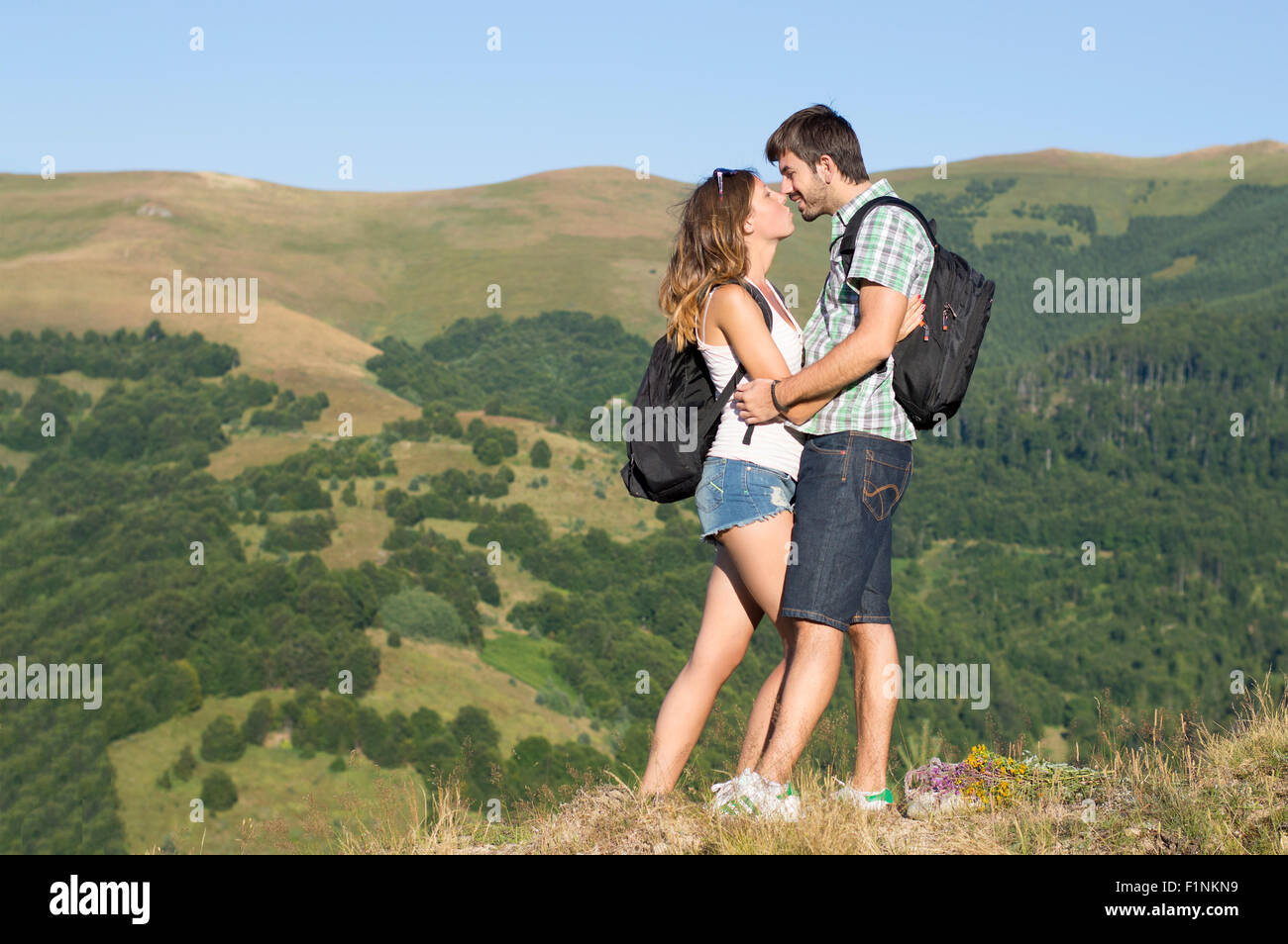 Happy hikers couple in love kissing in the mountains Stock Photo