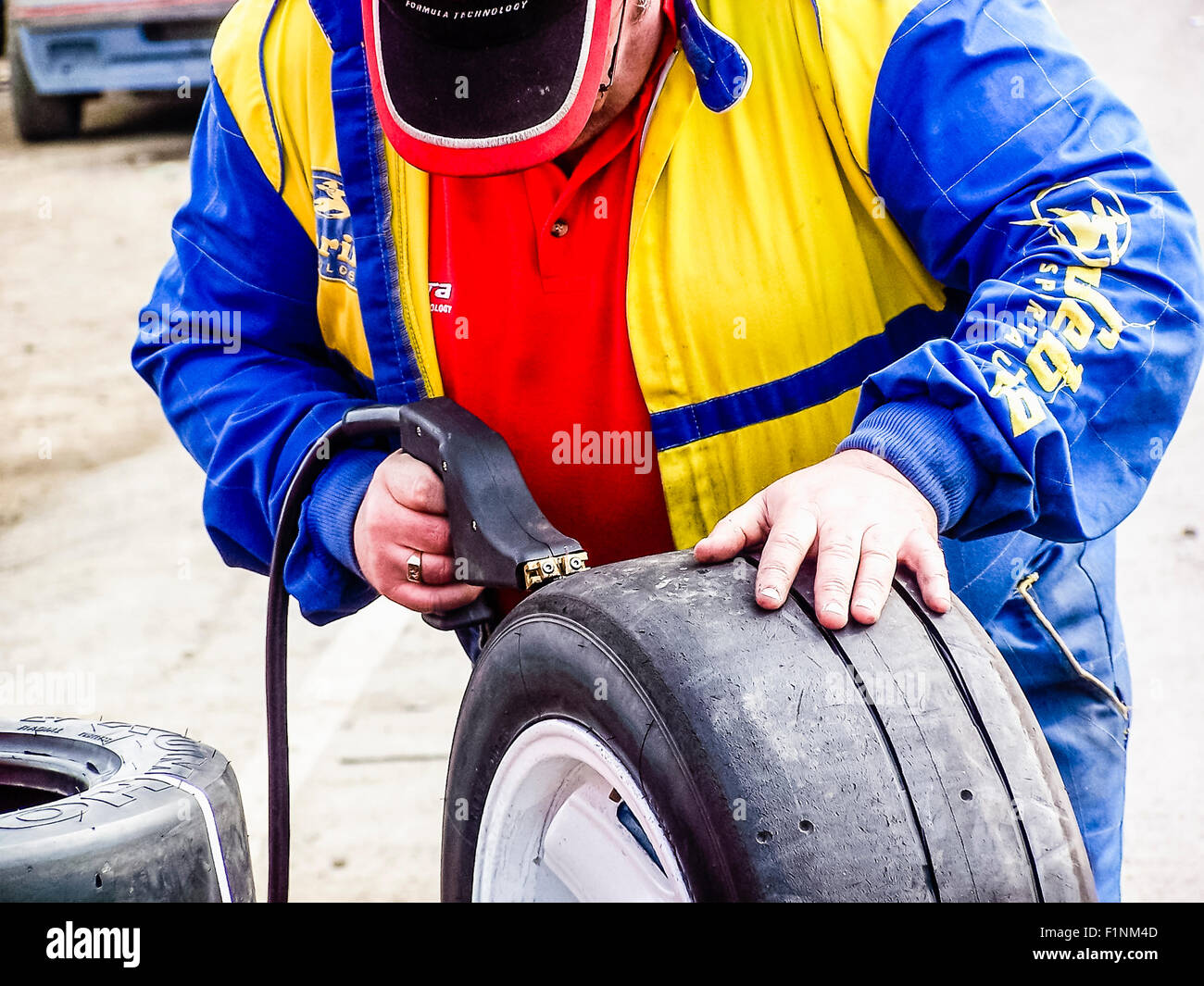 A mechanic uses a heat gun to re cut treads to add tread to a slick