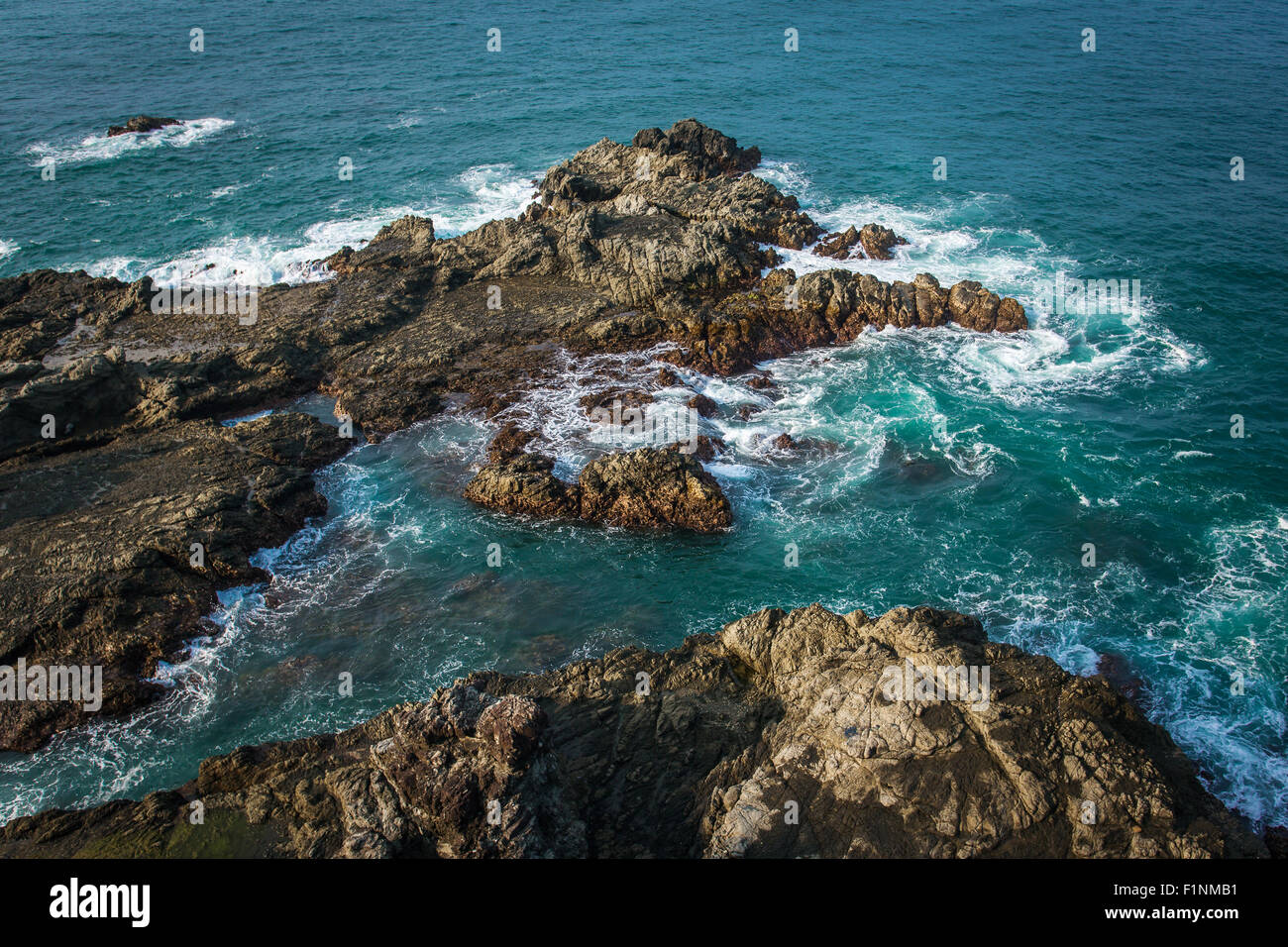 Rough wild sea water crashing into the rocks on Java, Indonesia Stock Photo