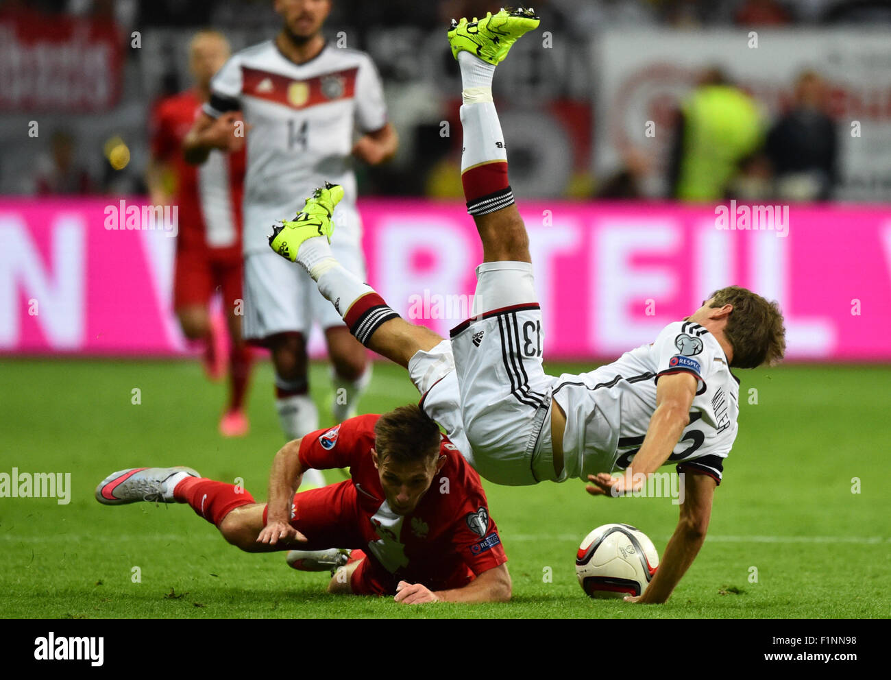 Germany's Thomas Mueller (top) and Poland'S Maciej Rybus compete for the ball during the Group D qualifier for the European Championships at the Commerzbank-Arena in Frankfurt am Main, Germany, 4 September 2015. PHOTO: UWE ANSPACH/DPA Stock Photo