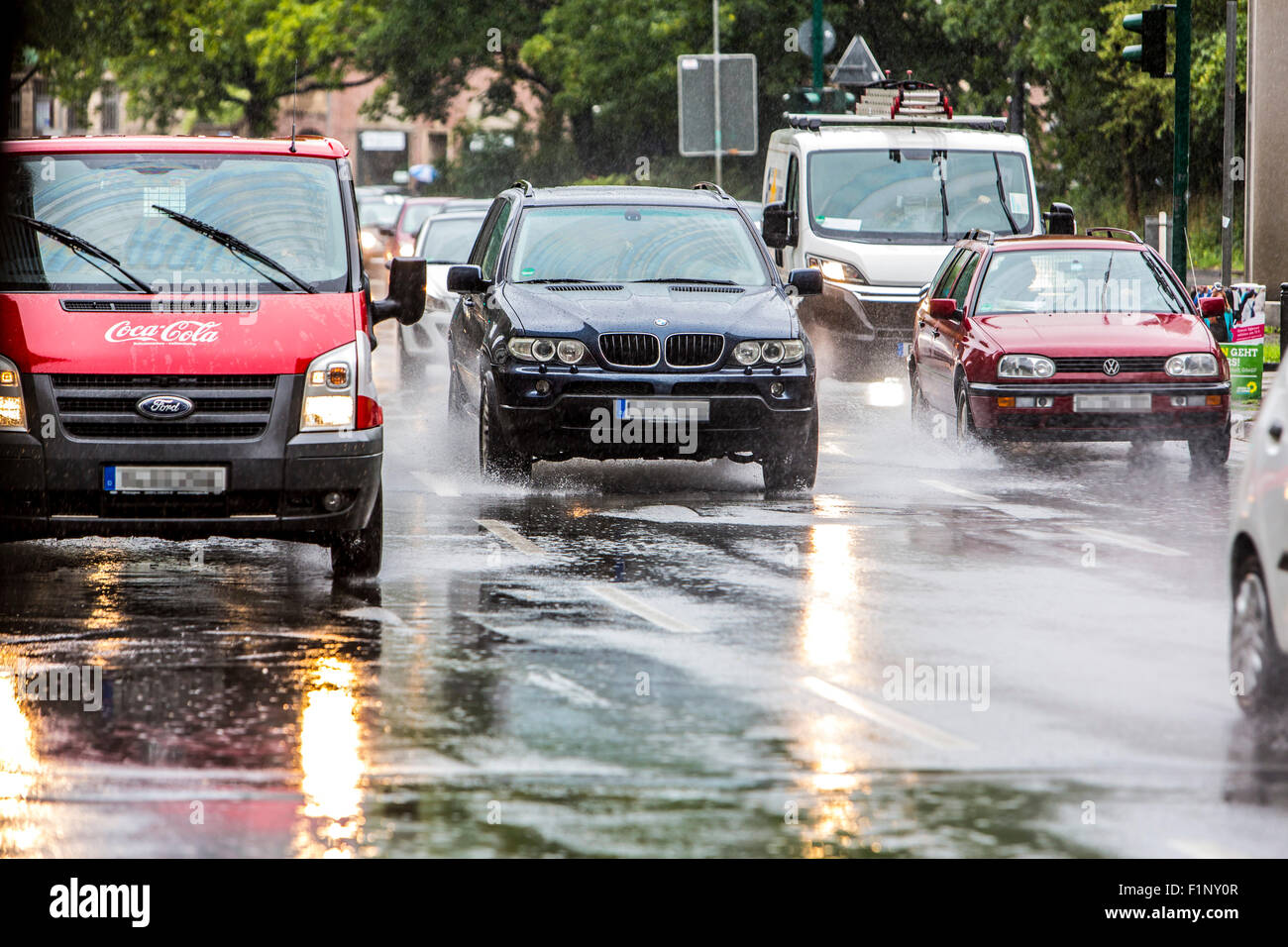 Cars driving in heavy rain weather, wet surface of the street