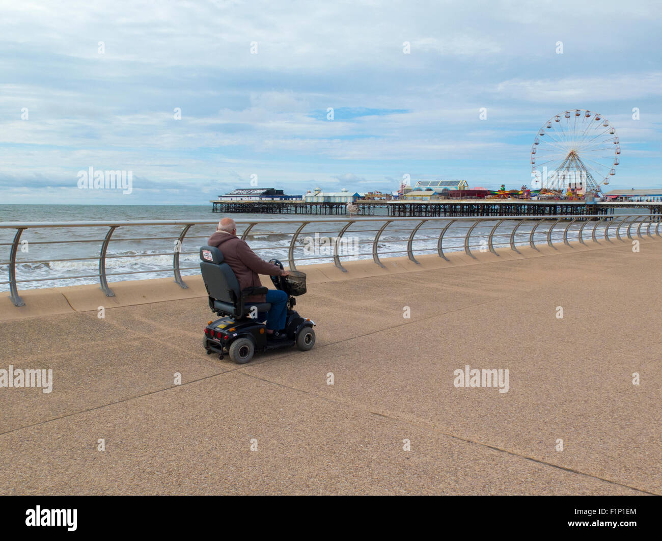 Disabled person on a scooter on Blackpool promenade Stock Photo