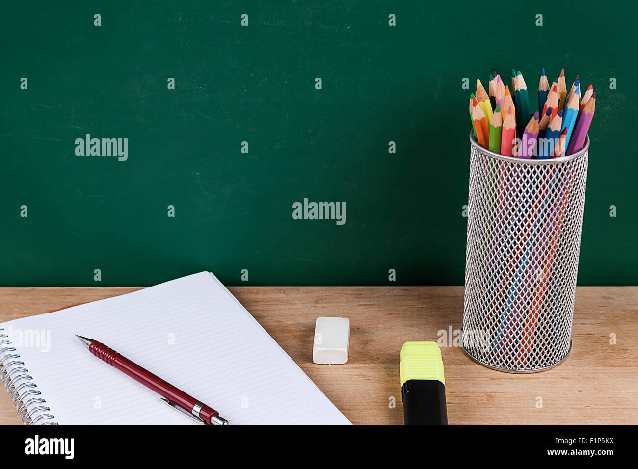Colored pencils on green chalkboard Stock Photo