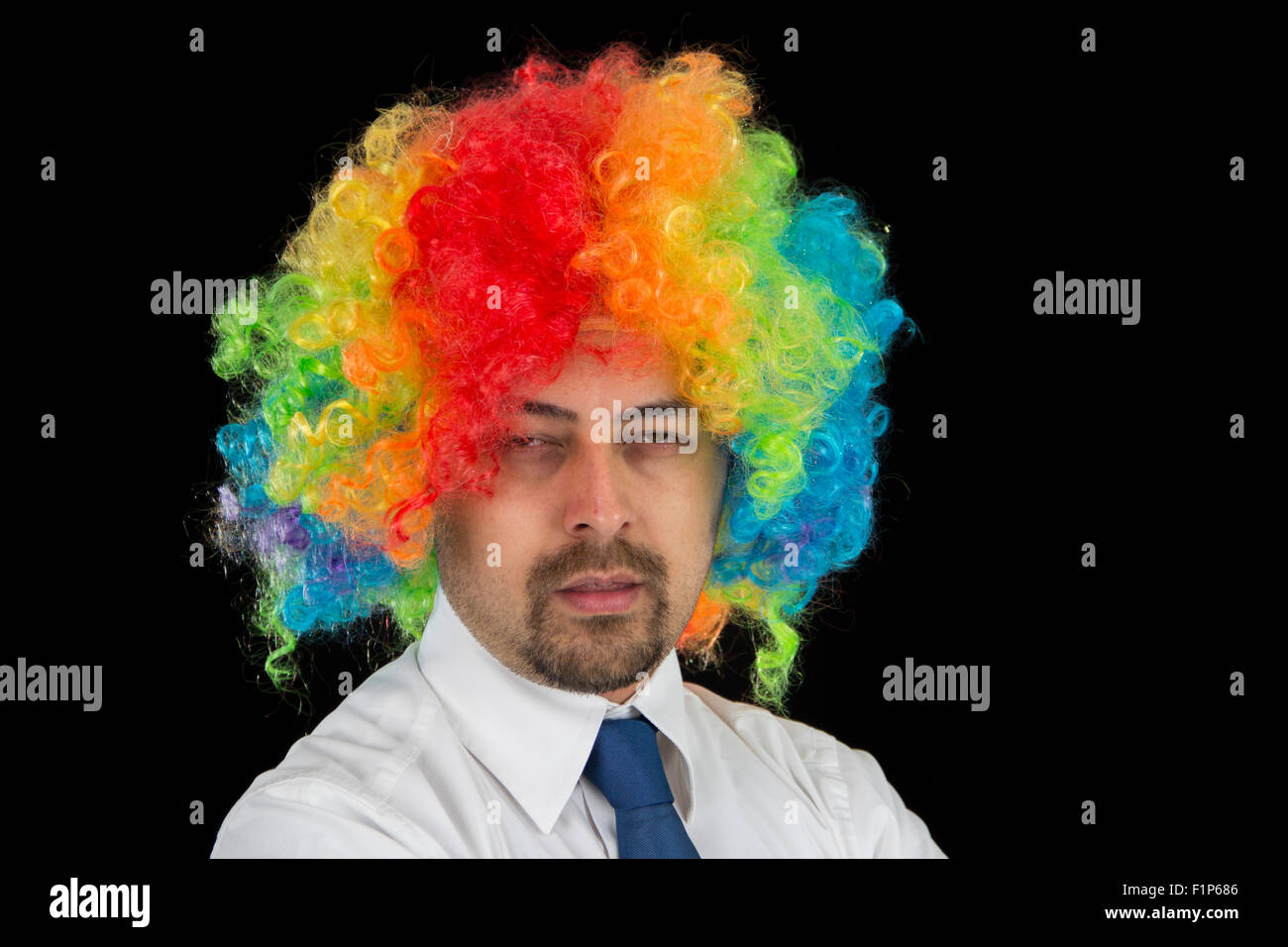business man wearing colorful wig looking bored Stock Photo