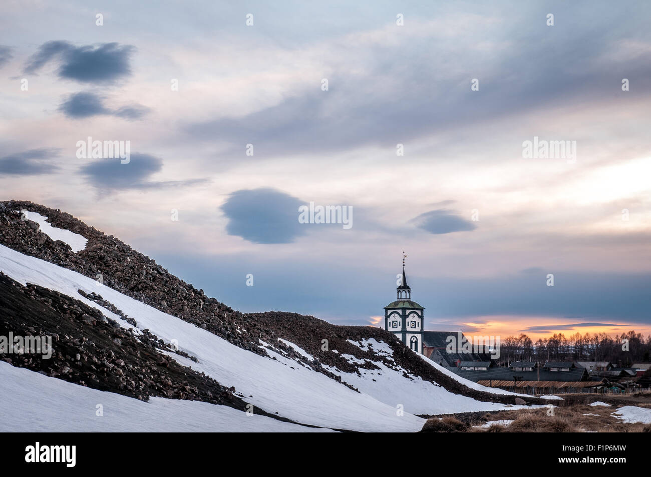 Røros church behind mounds of slag partially covered in snow Stock Photo