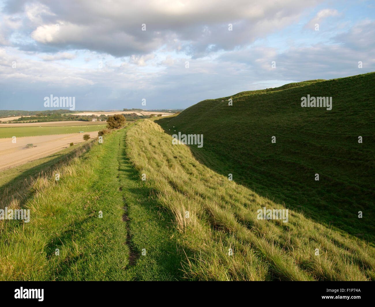 Footpath along the top of one of the lower ramparts, Maiden Castle, Iron age hill fort, Dorchester, Dorset, UK Stock Photo