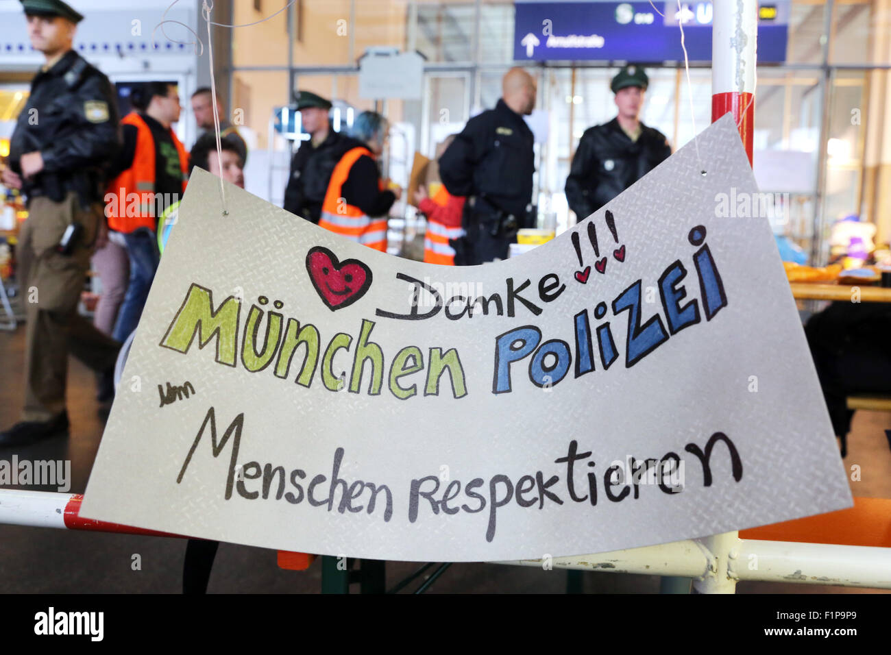 A hand-written sign says 'Thank you' to german Police for treating migrants with respect. Migrants from Syria, Afghanistan and other Countries arrived on a train from Budapest/Hungary at Munich Hauptbahnhof main railway station on August 31. 2015 in Munich, Germany. Thousands of migrants are traveling to Germany via Turkey, Greece, Montenegro, Serbia, Hungary and Austria. Stock Photo