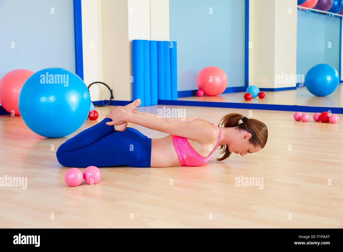Pilates woman fitball rocking exercise workout at gym indoor Stock