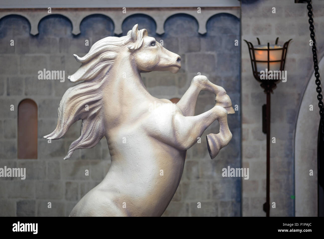 Statue of a rearing horse before a castle wall Stock Photo