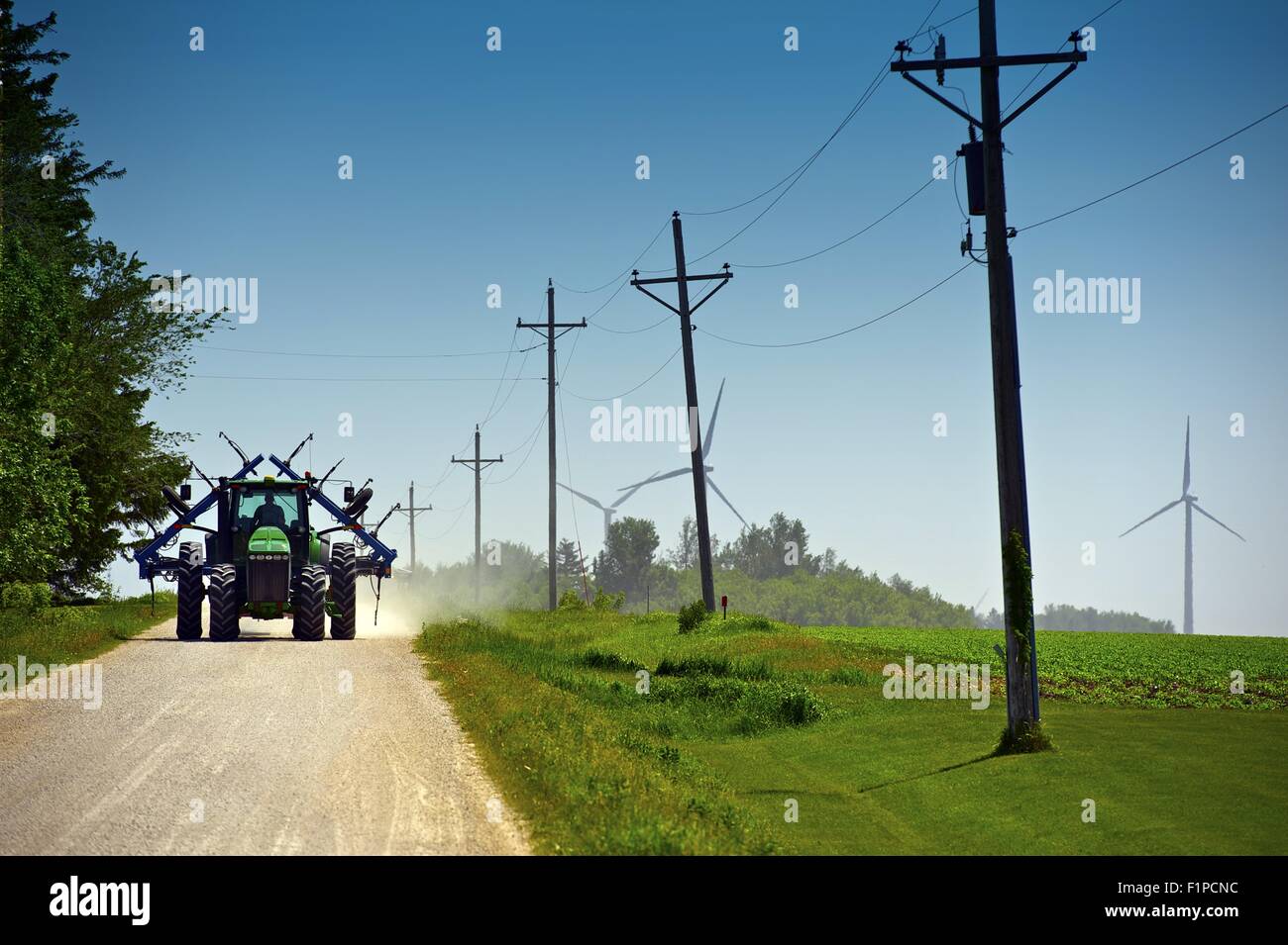 Minnesota Farmer on Suburb Road Riding Tractor with Farm Equipment. Old