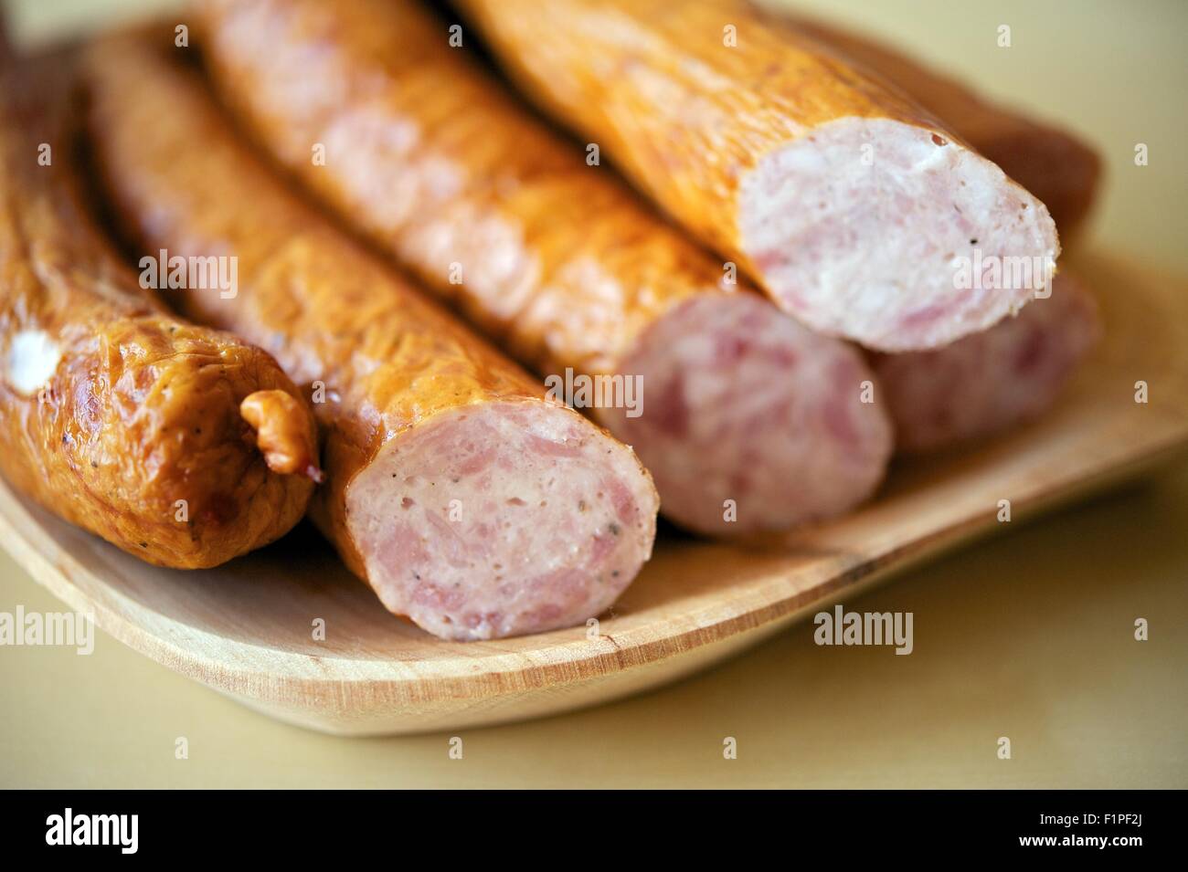 Polish Sausage on the Wood Plate. Polish Sausage Pieces ( Kielbasa ) on Wood Table. Stock Photo