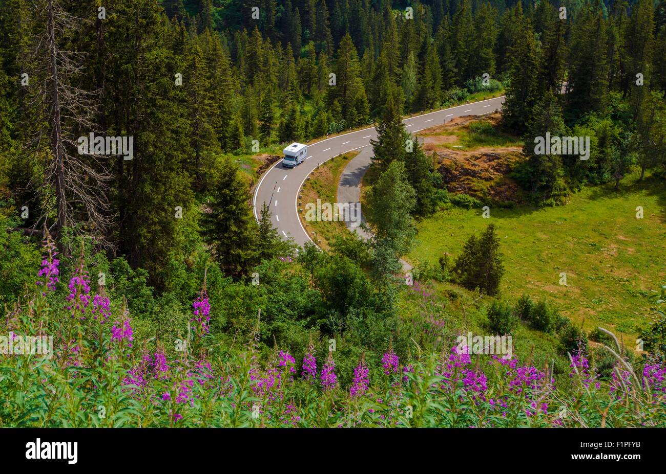 Camper Van Summer Travel. Rving Photo Theme. Small Class C Travel Camper on a Mountain Road During Summer Time. Stock Photo