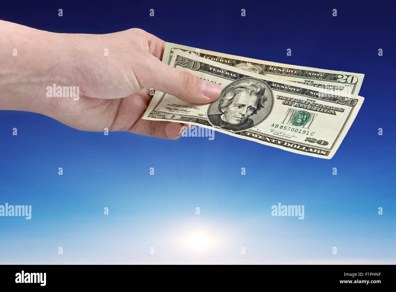 Men hand offer money over blue sky Stock Photo