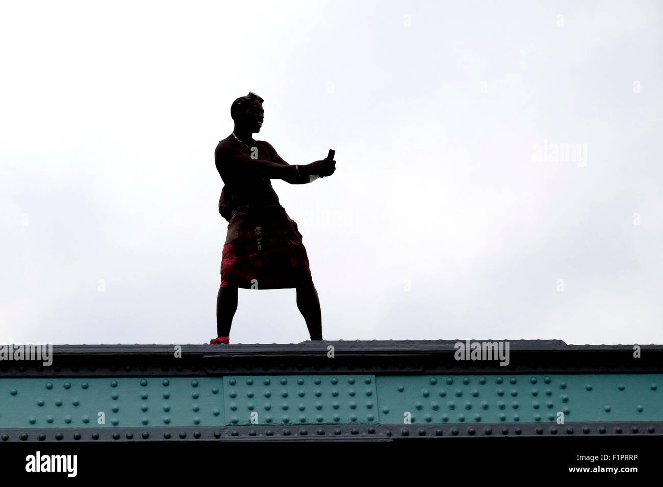 A man in silhouette takes photographs of the crowd from his smart phone, at the Notting Hill Carnival Stock Photo