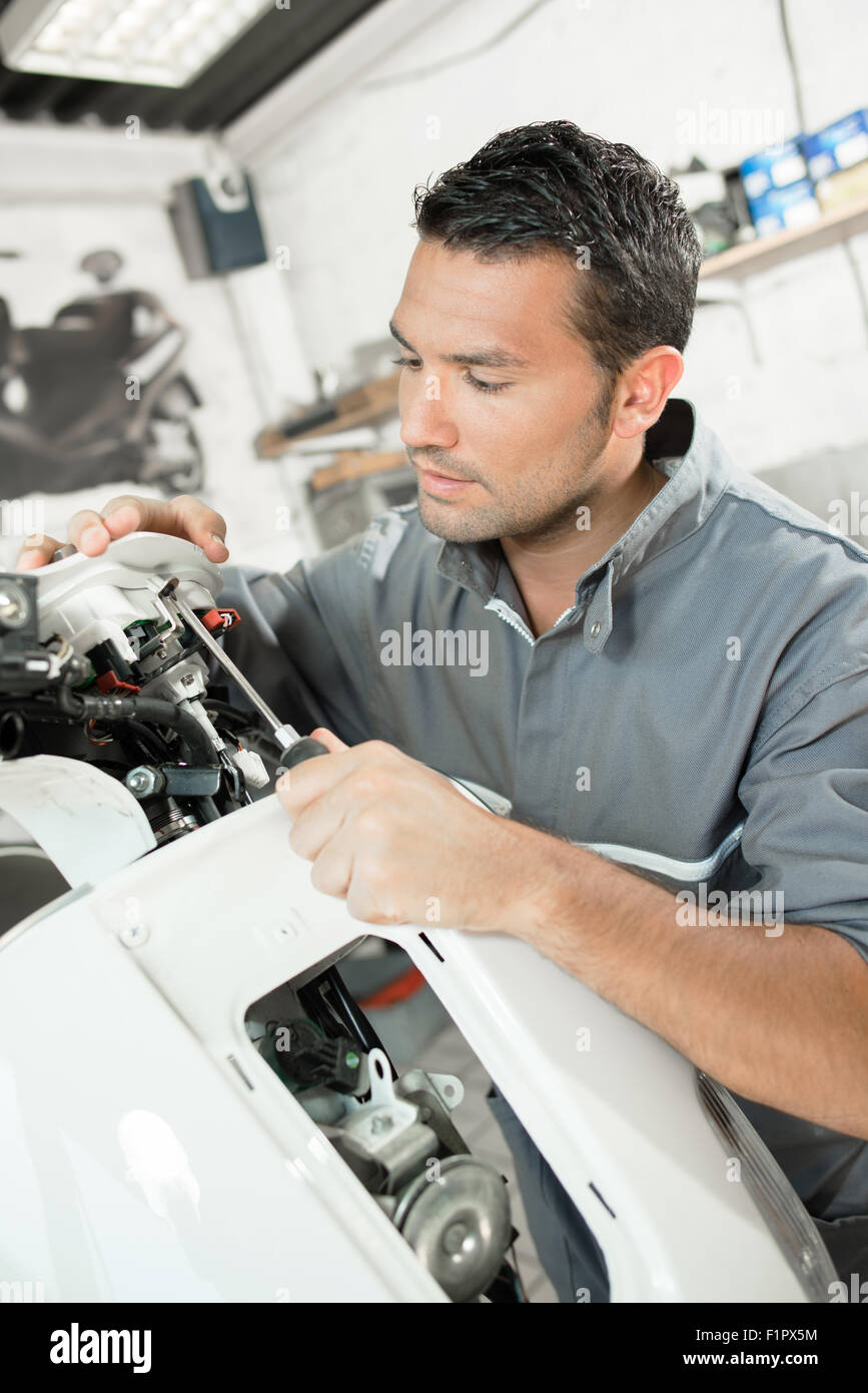Mechanic working on scooter Stock Photo Alamy