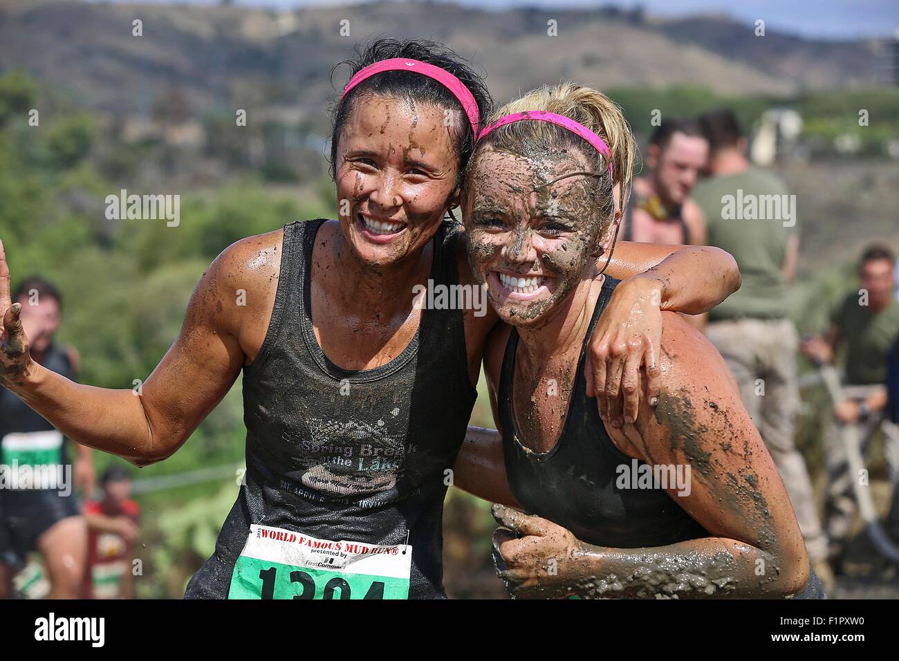 https://c8.alamy.com/comp/F1PXW0/two-women-competitors-smile-as-they-are-covered-in-mud-during-the-F1PXW0.jpg