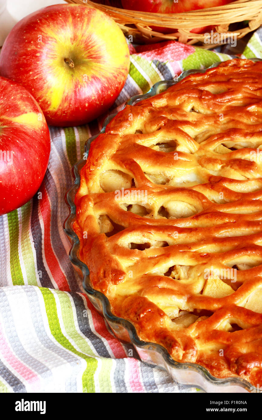 Apple pie with mesh decorated with flowers and apples on the table Stock Photo