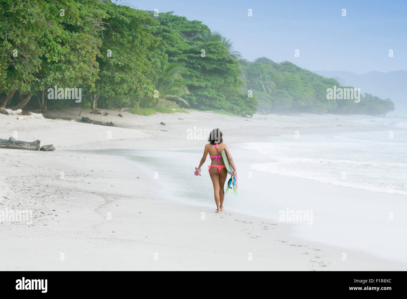 A Solo Female Surfer On A Beach In Santa Teresa Costa Rica