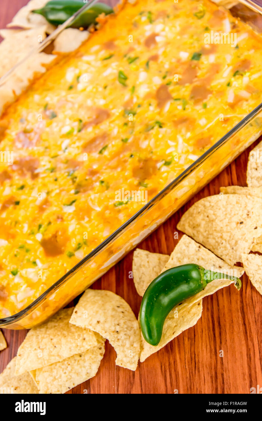 hot layered bean dip with jalapenos, sour cream and melted cheddar