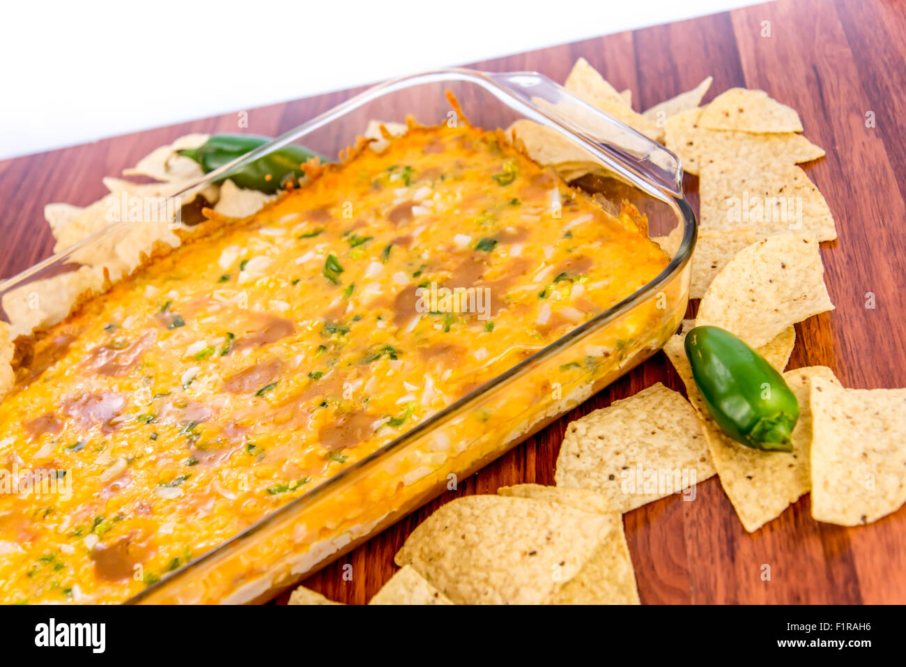 hot layered bean dip with jalapenos, sour cream and melted cheddar