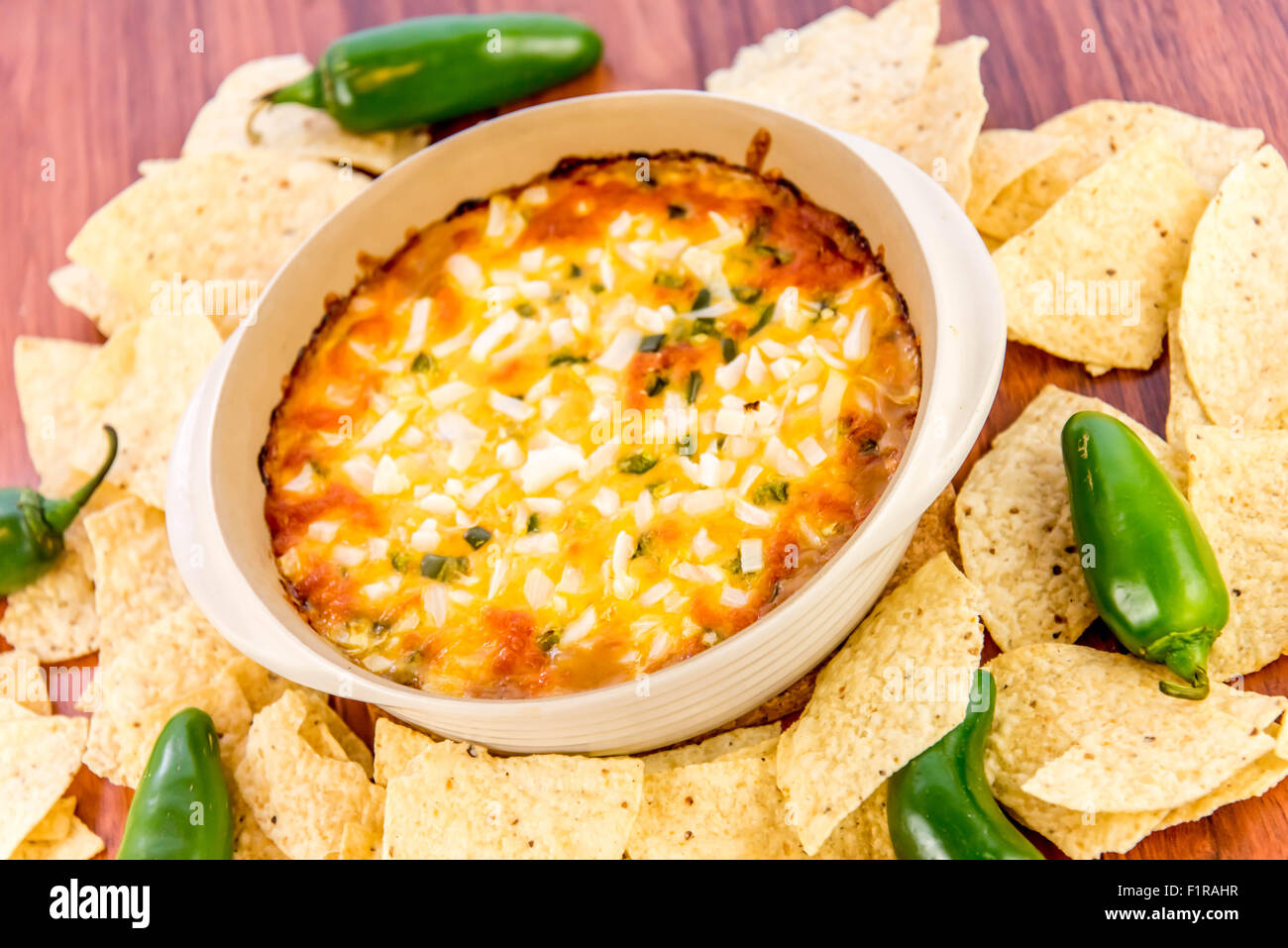 hot layered bean dip with jalapenos, sour cream and melted cheddar