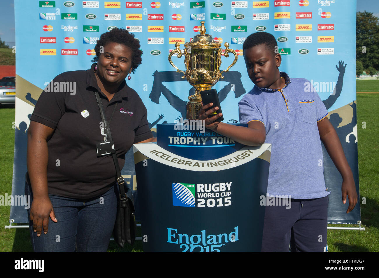 London, UK. 06th September 2015. Selfie moment with the Webb Ellis Cup for Amal whislt being photographed together with his mum Noreen as it was displayed at the East London RFC for the UK and Northern Ireland Rugby World Cup Trophy Tour. Credit: Elsie Kibue / Alamy Live News Stock Photo