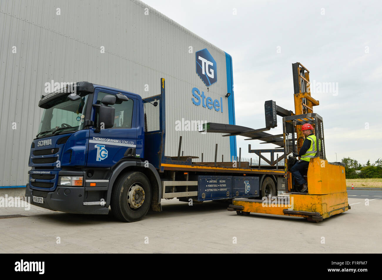 Thomas Graham, side loader forklift truck loading steel onto lorry Stock Photo
