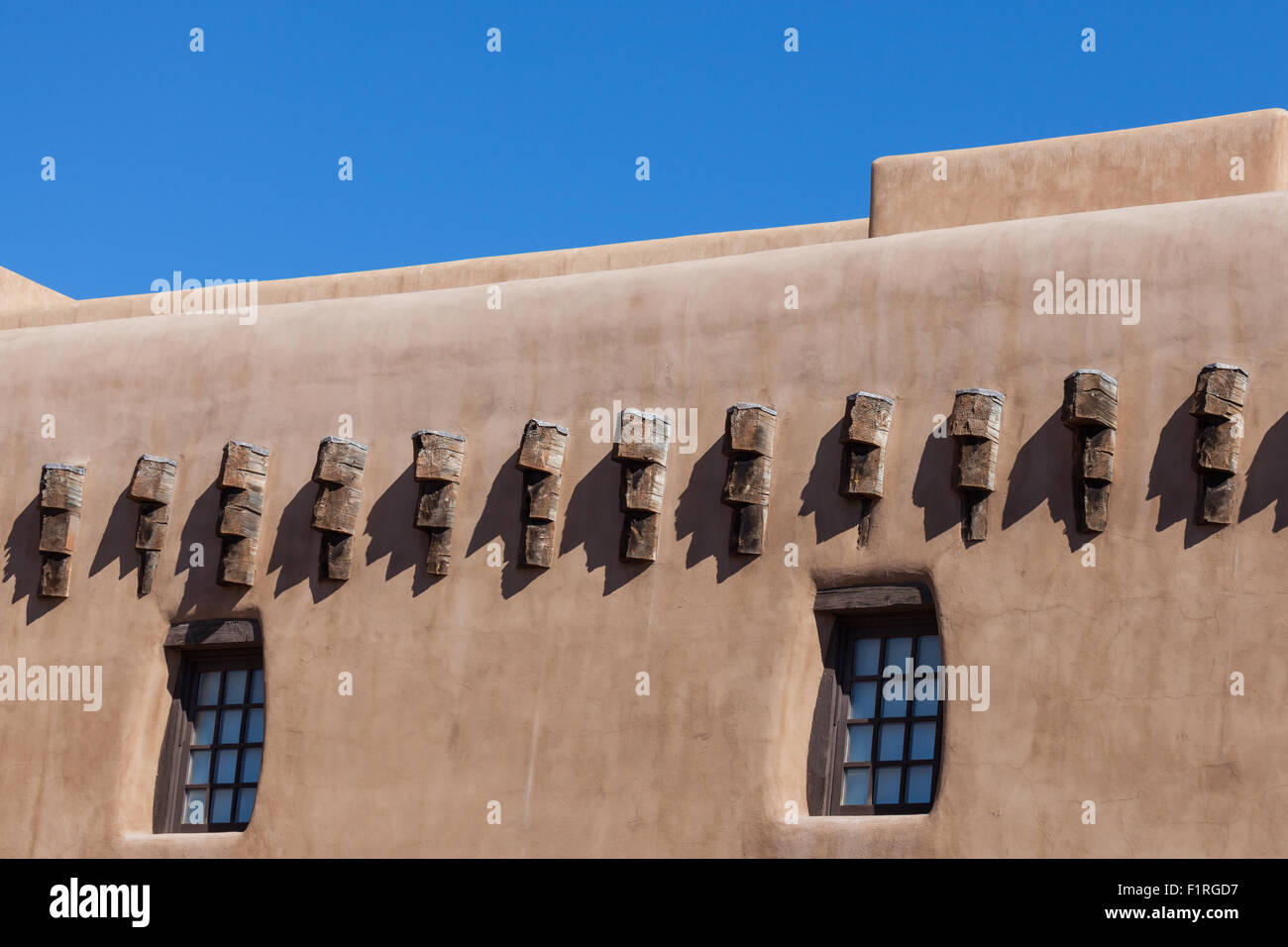 Adobe Building Windows A southwestern adobe style building with windows and beams in the ...