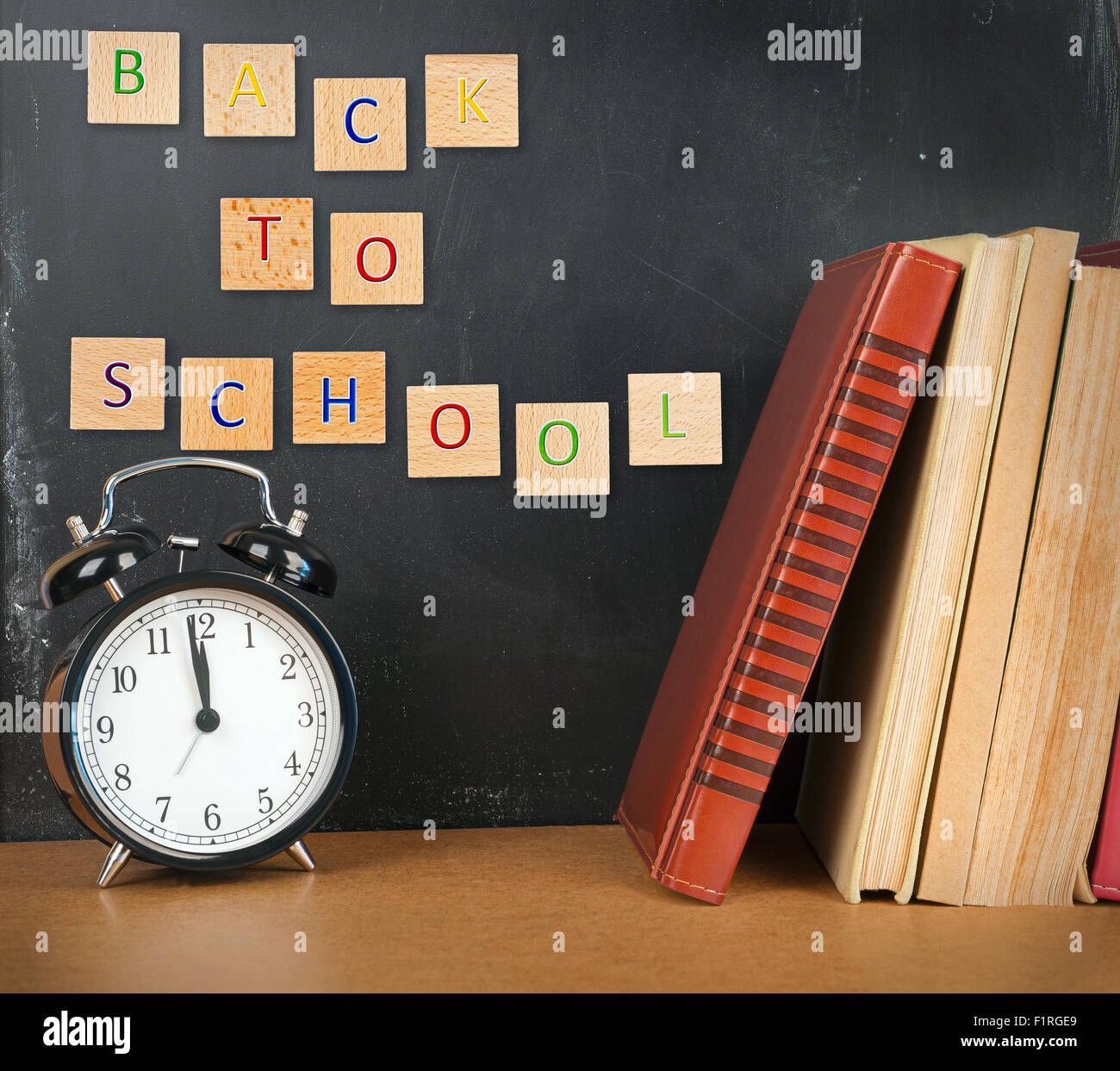 Back to school background with books, alarm clock and inscription Stock Photo
