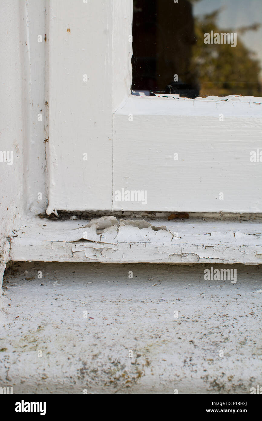 cracked paint peeling off external wooden window sill Stock Photo